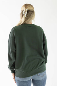 Back view of a woman wearing a dark green crewneck fleece sweatshirt and light wash jeans.