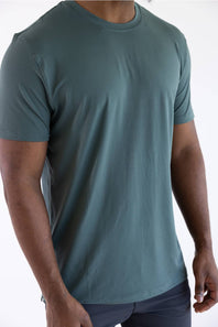 Close-up product shot of a man wearing the 7Diamonds Core Crew T-Shirt in Drake green, showing the short sleeves and relaxed fit.