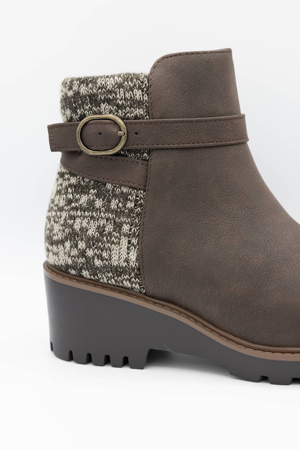 A brown suede ankle boot with a textured gray and white knit pattern panel on the side, a matching brown strap with a gold-tone buckle, and a chunky dark gray lug sole.