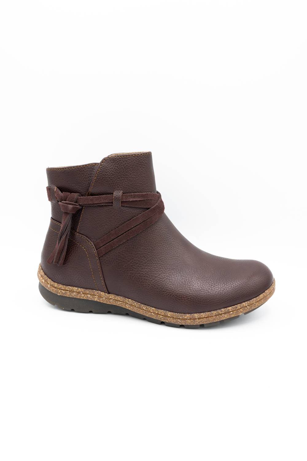 A dark brown faux-leather ankle boot with a textured finish, featuring a decorative side strap with a tassel, a cork-wrapped midsole, and a black outsole, shown against a plain white background.