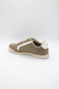 A low-top sneaker in taupe brown suede and canvas with a contrasting white side stripe, white heel tab, and white sole, shown from a side profile view on a light gray background.