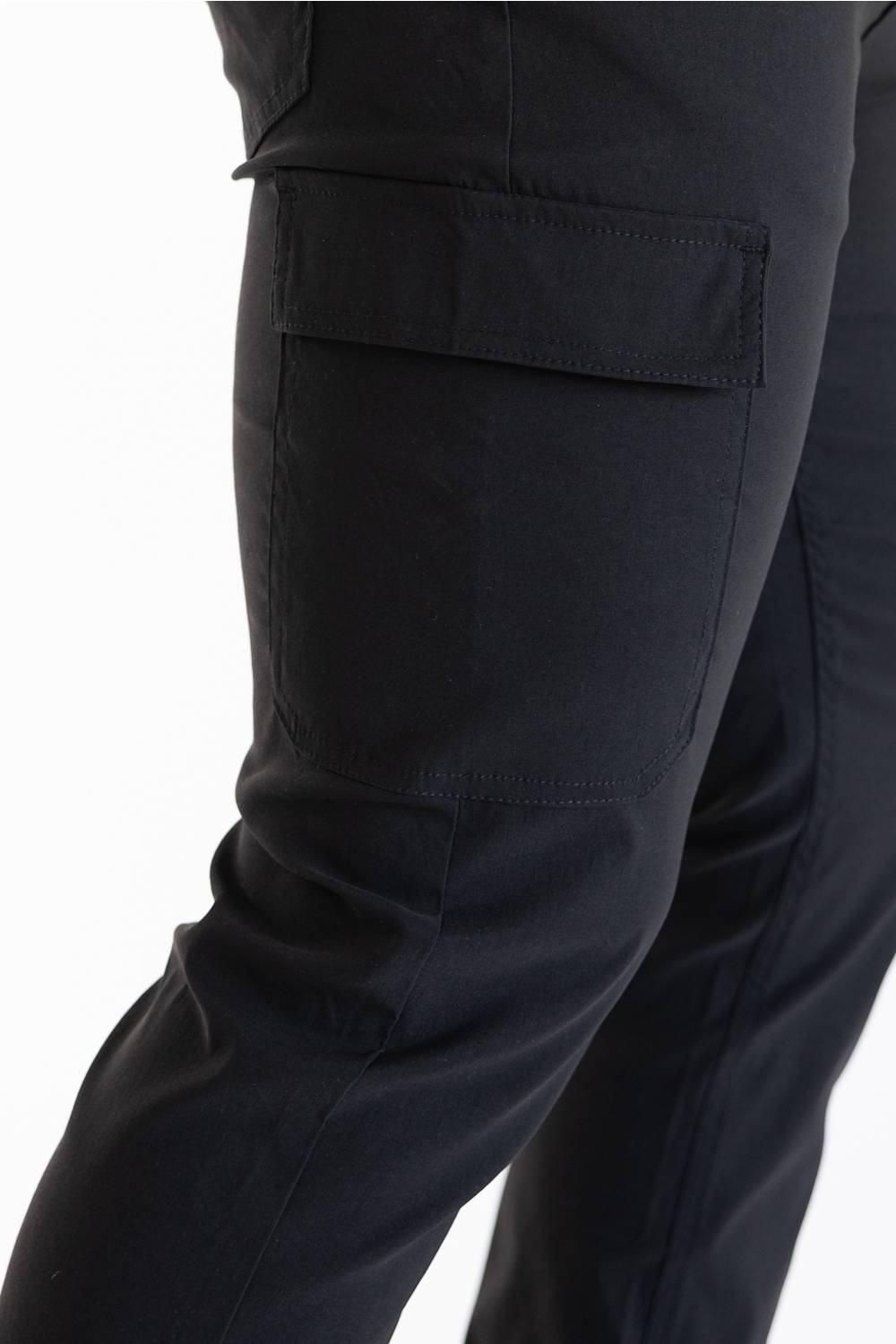 Close-up of a person's leg wearing black cargo pants, showing a side pocket detail against a plain white background.