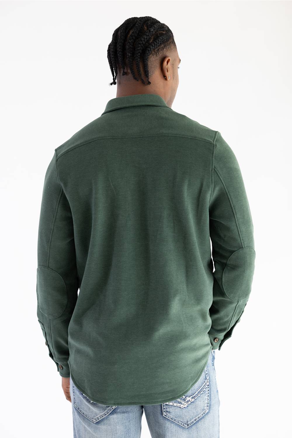 A man viewed from behind wearing a dark green long-sleeve button-up shirt and light blue jeans against a plain white background.