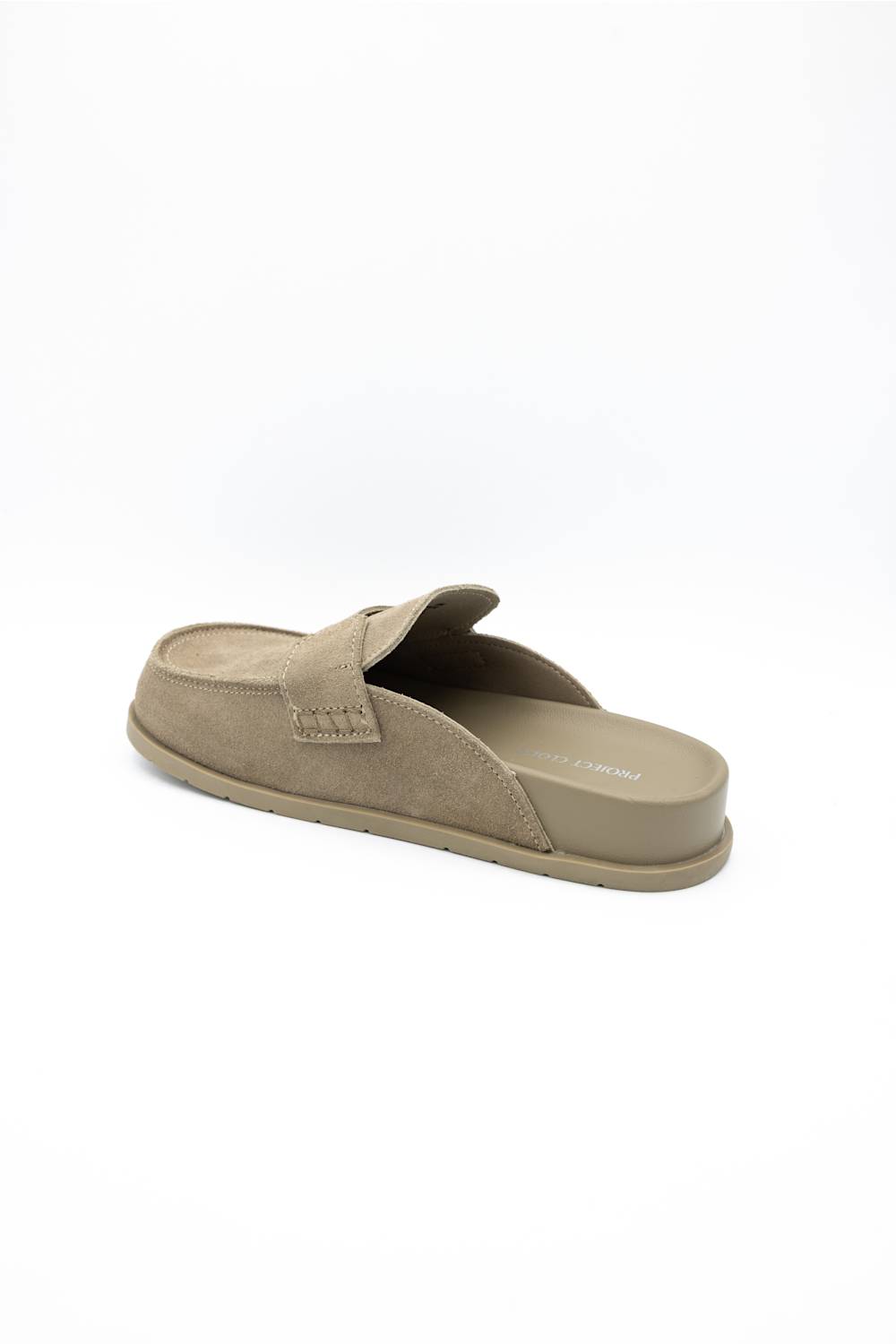 A single taupe-colored slip-on mule shoe with a suede-like upper and matching sole, shown from a side-rear angle on a white background.