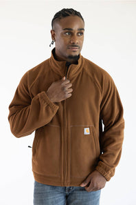 Male model wearing the brown Carhartt Elkhart fleece jacket featuring a full zipper, mock neck collar, elastic cuffs, and the Carhartt logo patch on the left front pocket.