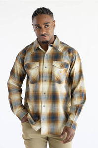 A man wearing a Carhartt long-sleeve plaid button-up shirt in beige, brown, and blue tones, paired with khaki pants, against a plain white background.