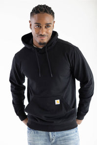 Front view of a man wearing a black Carhartt hooded sweatshirt featuring a front kangaroo pocket with the iconic Carhartt brand logo patch attached.