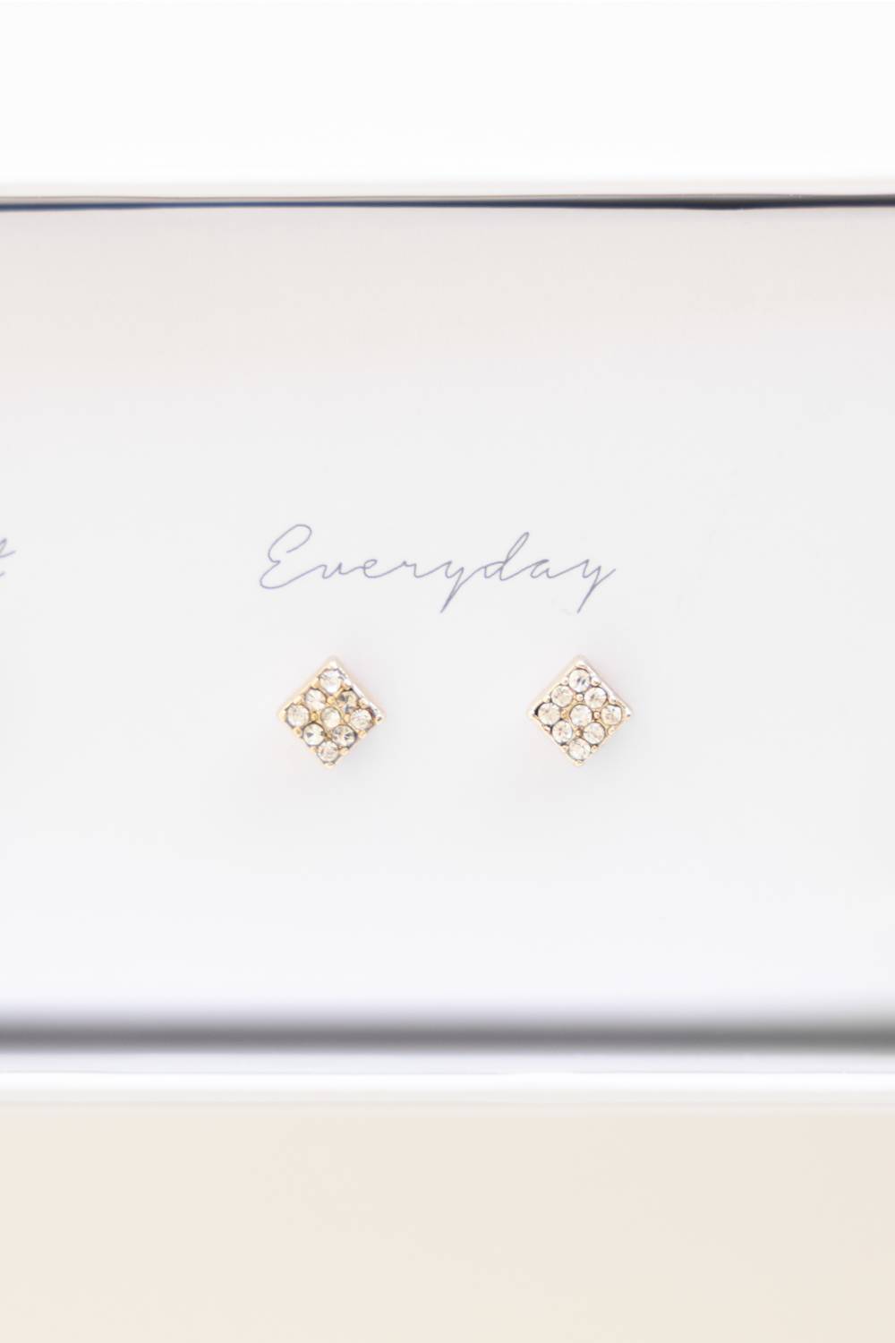 A pair of small gold stud earrings with clustered clear stones, displayed on a white card that reads 'Everyday' inside a white box.