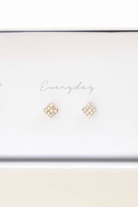 A pair of small gold stud earrings with clustered clear stones, displayed on a white card that reads 'Everyday' inside a white box.