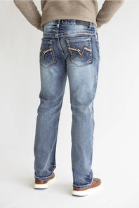 Rear view of a person wearing light-wash blue jeans with decorative contrast stitching on the back pockets, paired with a beige sweater and brown shoes, against a plain light background.