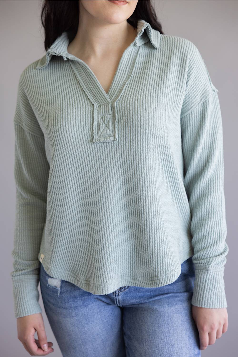 Ribbed v-neck sweater with long sleeves and exposed seams in light teal