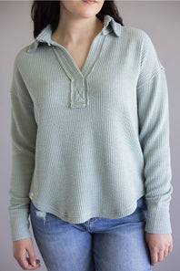 Ribbed v-neck sweater with long sleeves and exposed seams in light teal