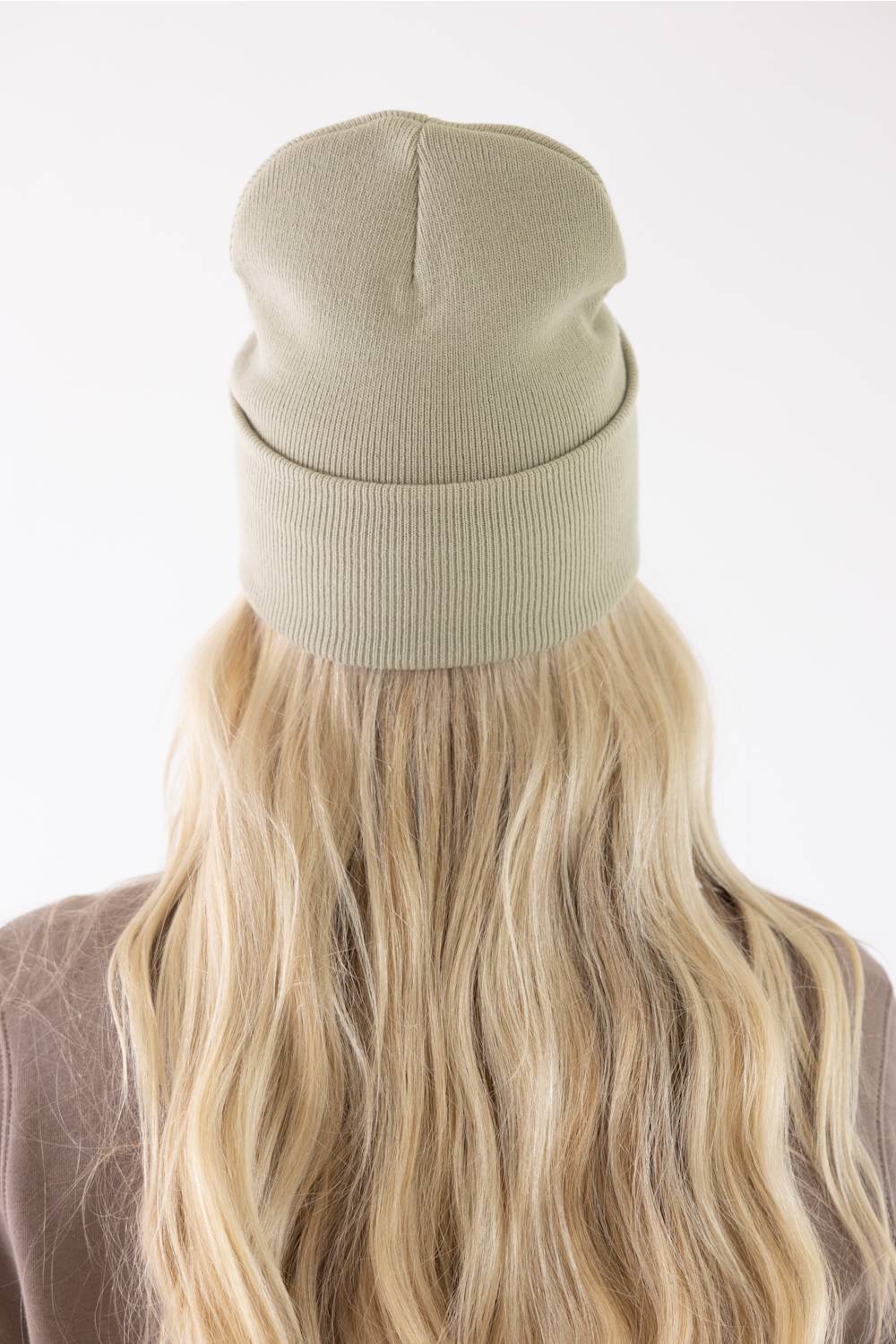 Carhartt Faded Fatigue Olive beanie with red heart patch worn by a smiling woman.
