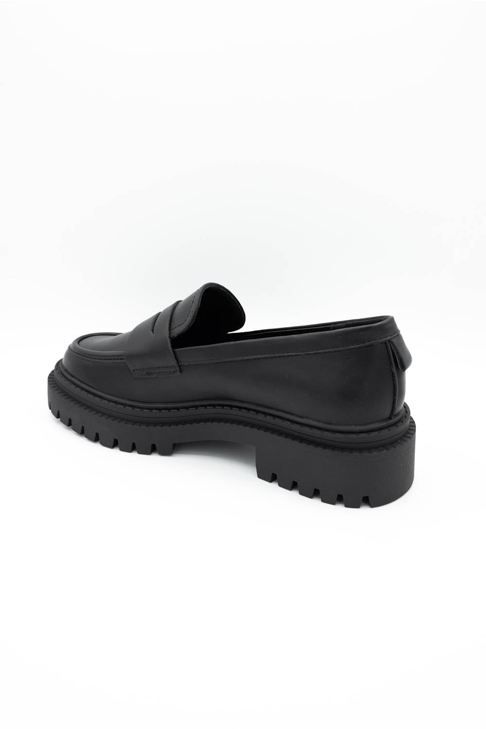 A single black leather penny loafer with a chunky lug sole, shown from a side-rear angle on a plain white background.