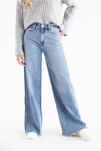 Model posing with a wide leg jean, cropped grey sweater