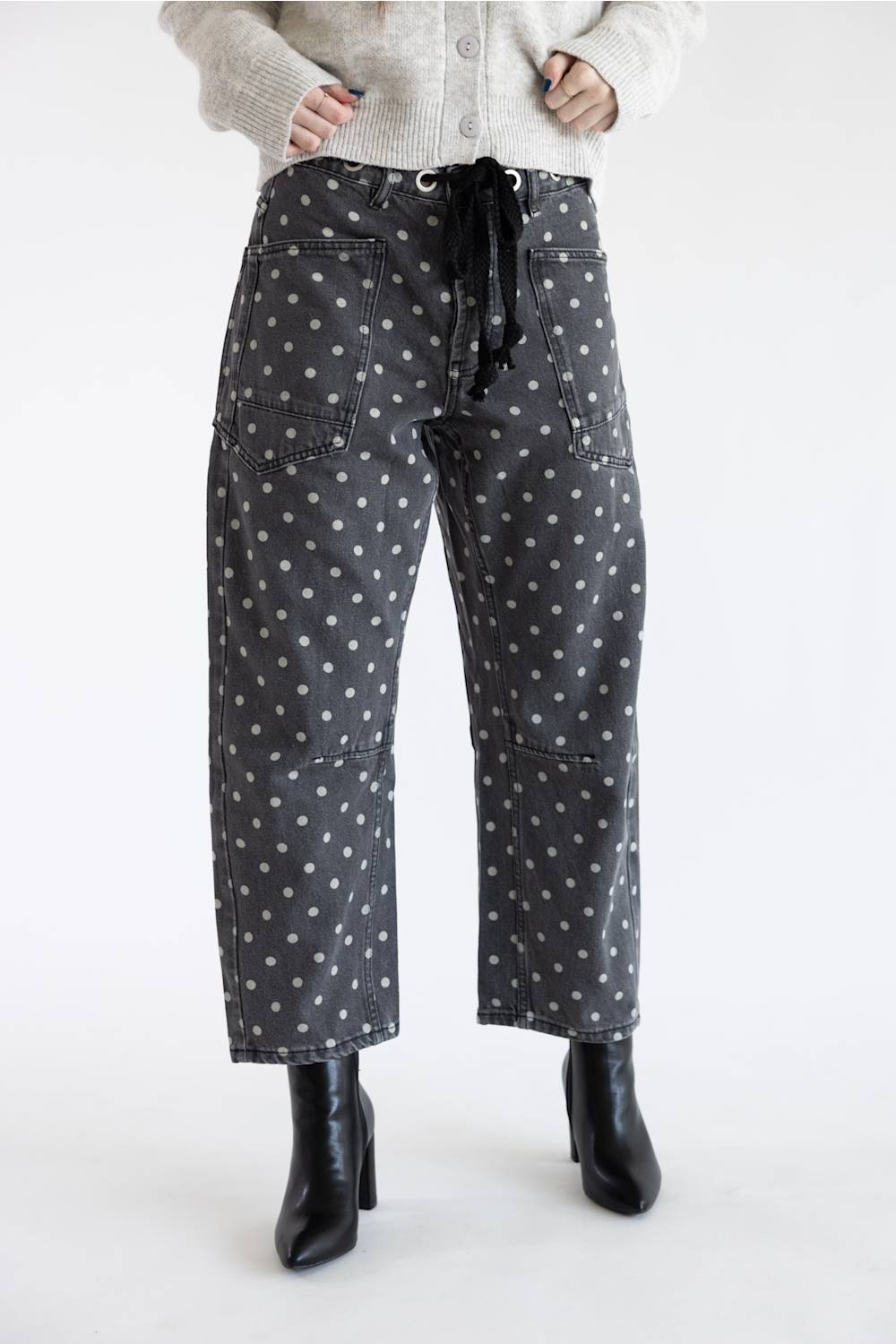 Front view of Aaron & Amber Drawstring Polka Dot Barrel Jeans in black showing full-length barrel silhouette, drawstring tie, and black heeled boots.