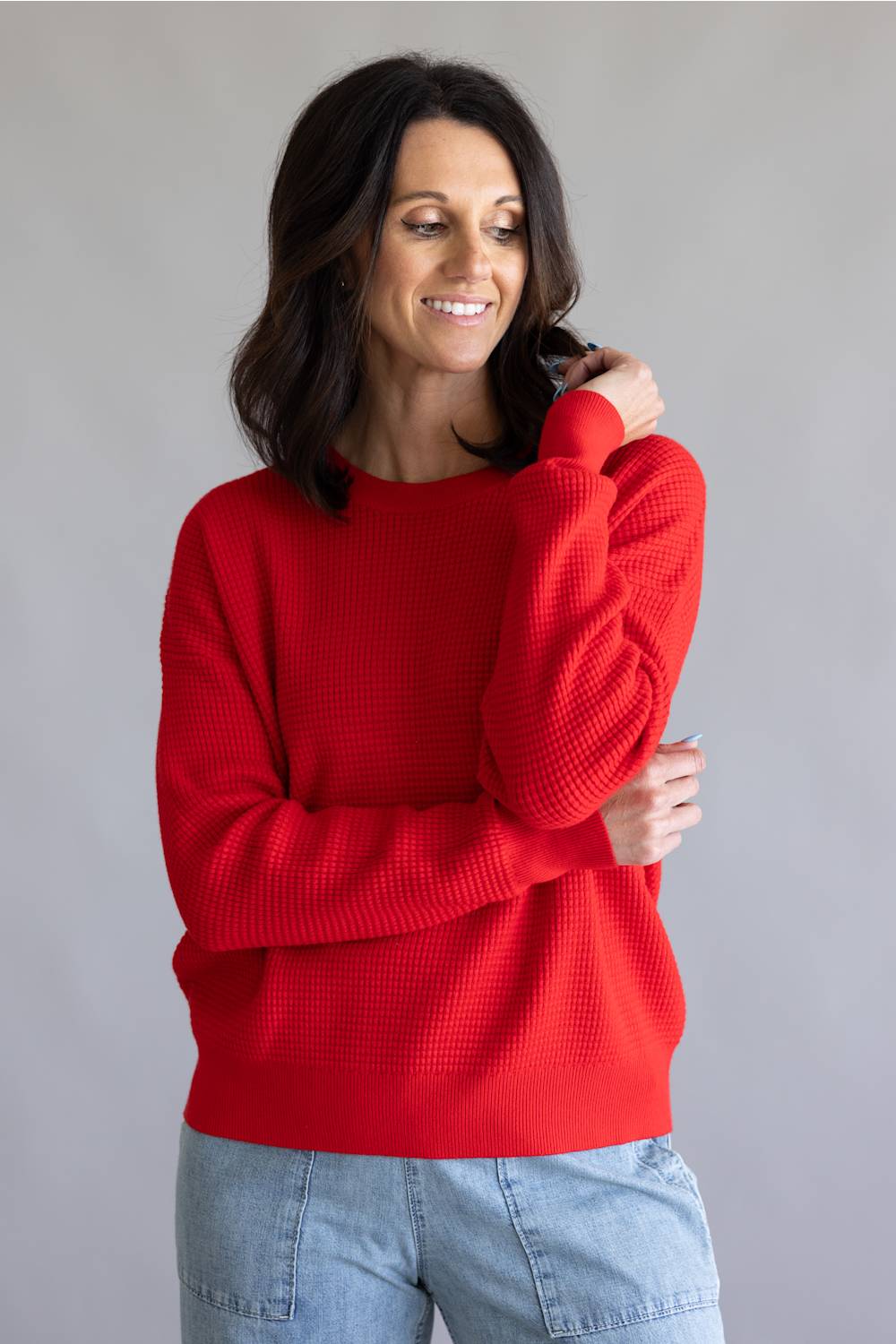 Waffle textured sweater top in a vibrant red color, with thick hems and cuffs 