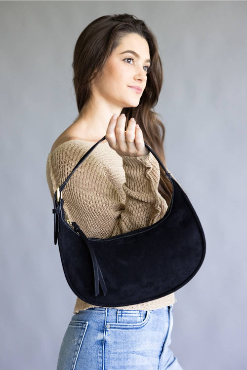 Crescent shaped faux suede shoulder bag with an adjustable buckle detail on strap