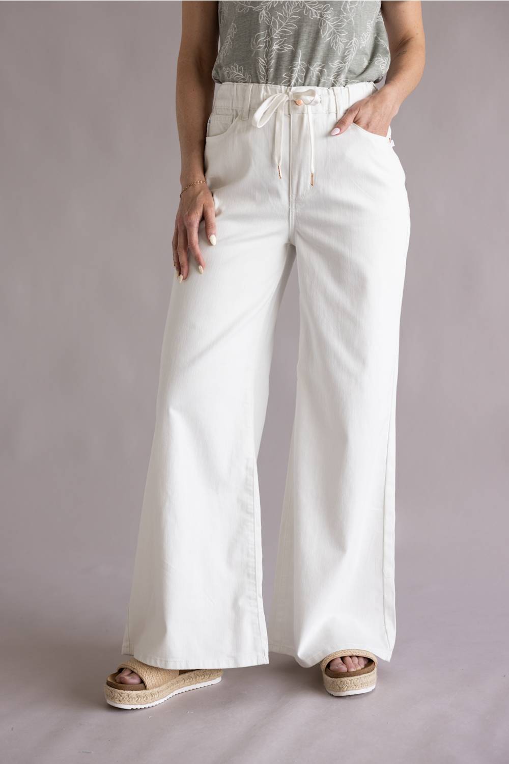 Judy Blue White Featherweight Palazzo Jeans for Women in White; Person wearing white wide-leg pants with a plain background