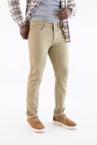 A person wearing slim-fit beige chino pants, styled with a gray t-shirt, an open plaid flannel shirt, and brown suede sneakers, photographed against a clean white background.