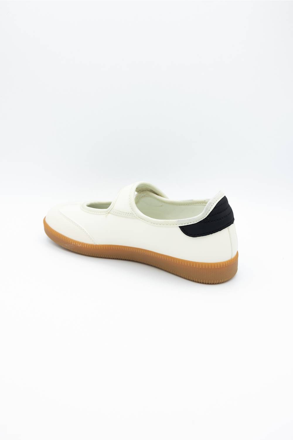 A single white slip-on shoe with a black heel tab and a tan gum sole, shown from a side-rear angle on a white background.