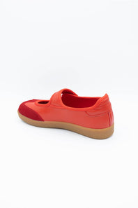 A red slip-on shoe with a gum sole, shown from a side-rear angle on a white background.