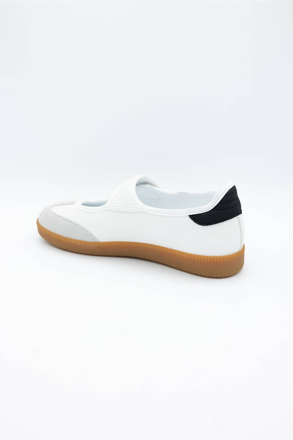 A white slip-on shoe with a black heel tab and a brown gum sole, shown from a side-rear angle on a white background.