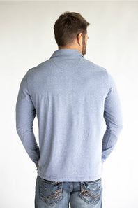 A man viewed from behind wearing a light heather gray long-sleeve shirt and blue jeans with decorative stitching on the back pockets, set against a plain white studio background.