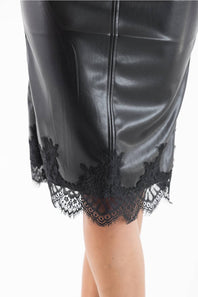 Close-up of a black faux-leather skirt with a scalloped black lace hem, shown on a model against a white background.