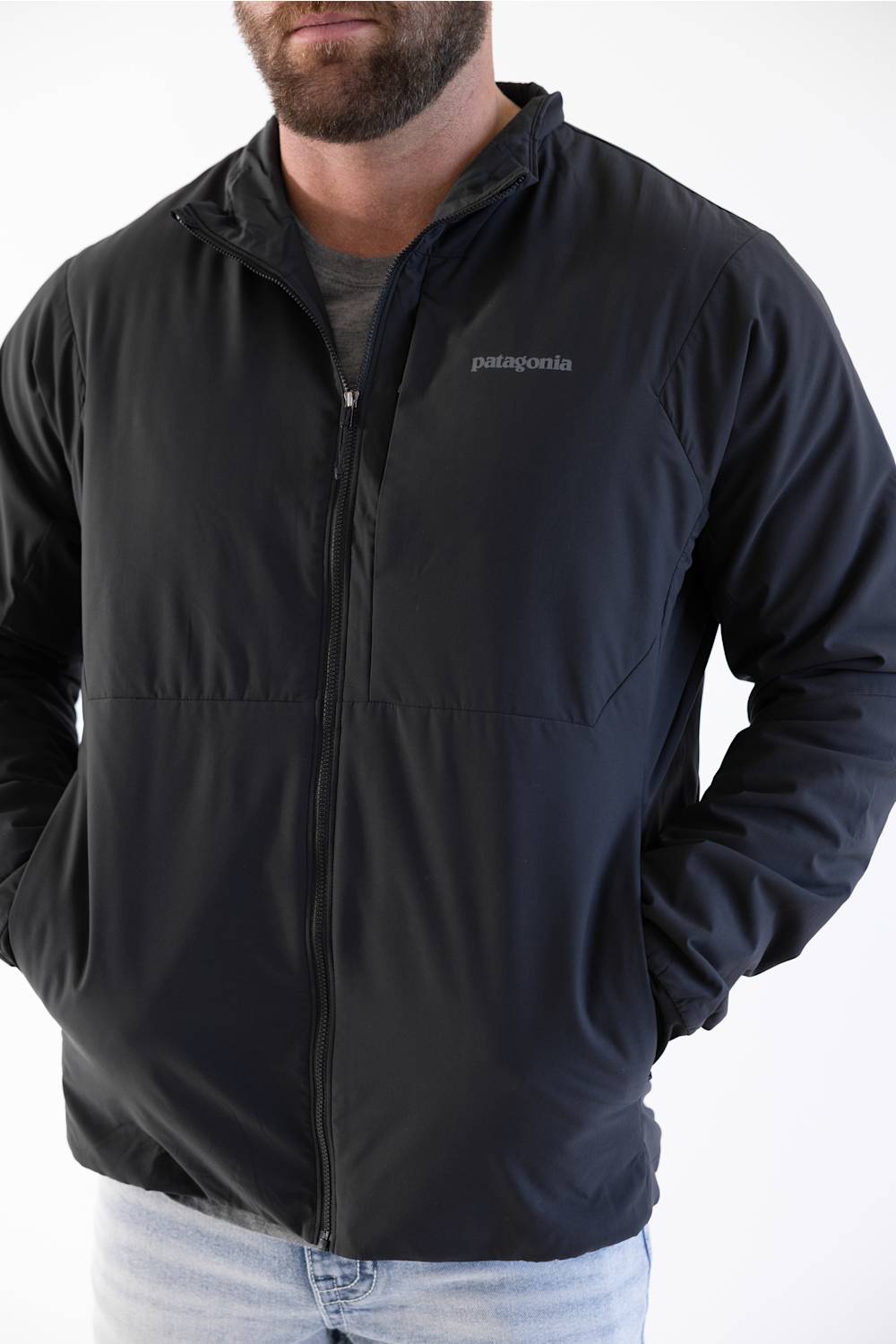 man standing in front of a white background  in a patagonia jacket 
