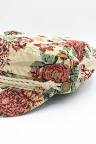 up-close of floral newsboy hat, with rope and button detail