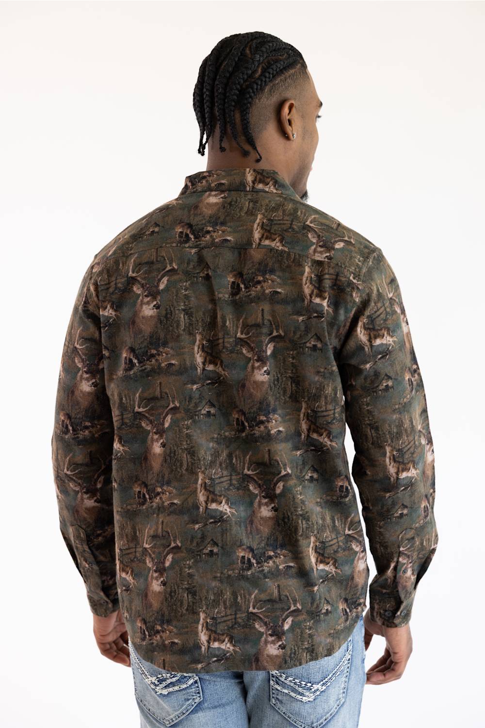 A man viewed from the back wearing a long-sleeve button-up shirt with an all-over deer camouflage pattern in shades of brown, green, and black, paired with blue jeans against a plain white background.