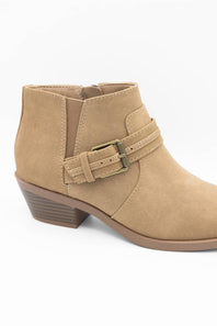 A tan suede ankle boot with a side buckle strap and a low stacked heel, shown from a side profile view on a white background.
