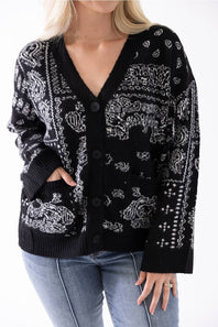 woman modeling a black paisely printed cardigan with jeans