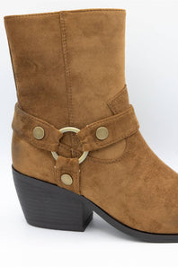 A brown suede ankle boot with a black block heel and a decorative strap featuring gold-tone metal hardware, shown against a plain white background.