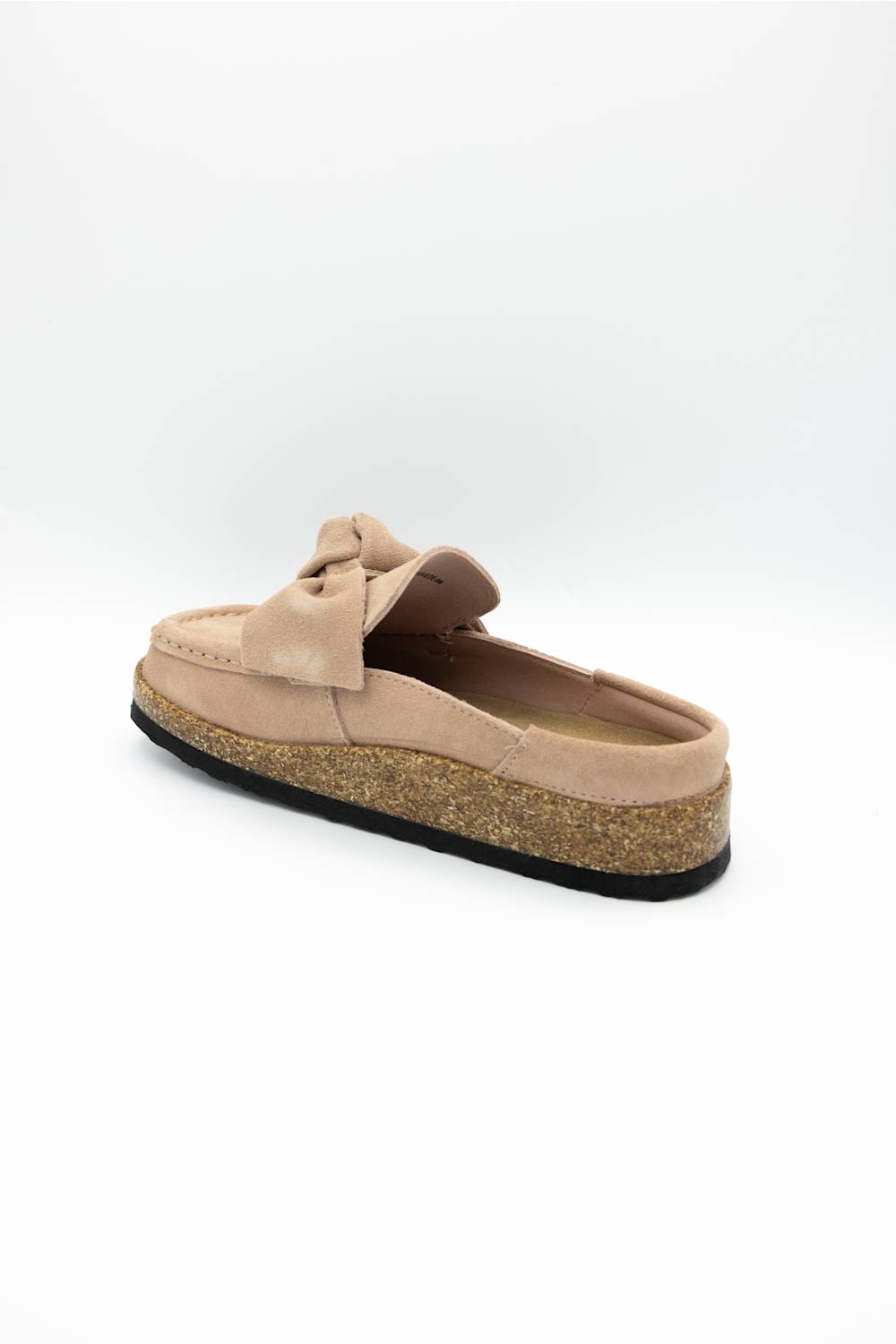 A single slip-on mule shoe in blush suede with a matching fabric bow on the vamp and a cork-textured midsole, shown against a plain white background.