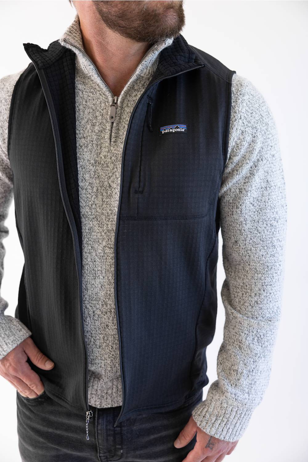 Patagonia Men's R1 Vest in Black styled over a heather grey quarter-zip sweater