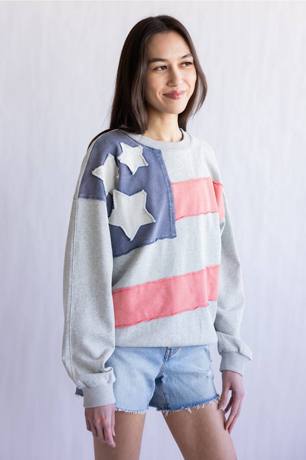 Flag USA Sweatshirt for Women in Grey; Woman wearing a sweater with an American flag design against a plain background