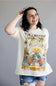 Woman wearing a graphic t-shirt with tropical design and text