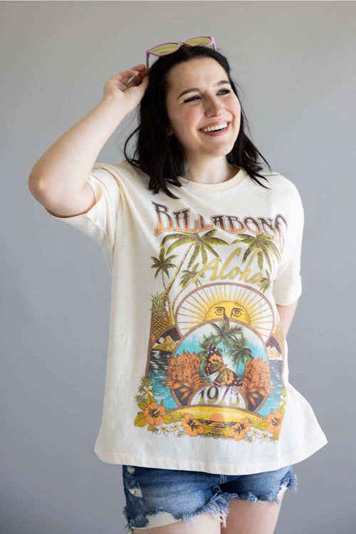 Woman wearing a graphic t-shirt with tropical design and text