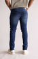 Person wearing blue jeans and a light-colored shirt on a plain background, showing two back pockets. The blue jeans are named Weatherproof Vintage Slim Jeans for Men in Silt Blue.