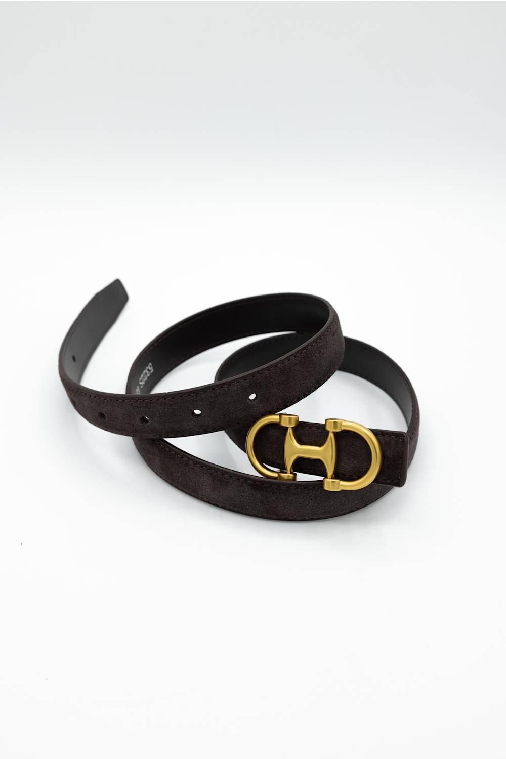 A dark brown suede belt with a gold-tone horsebit buckle, coiled on a white background.