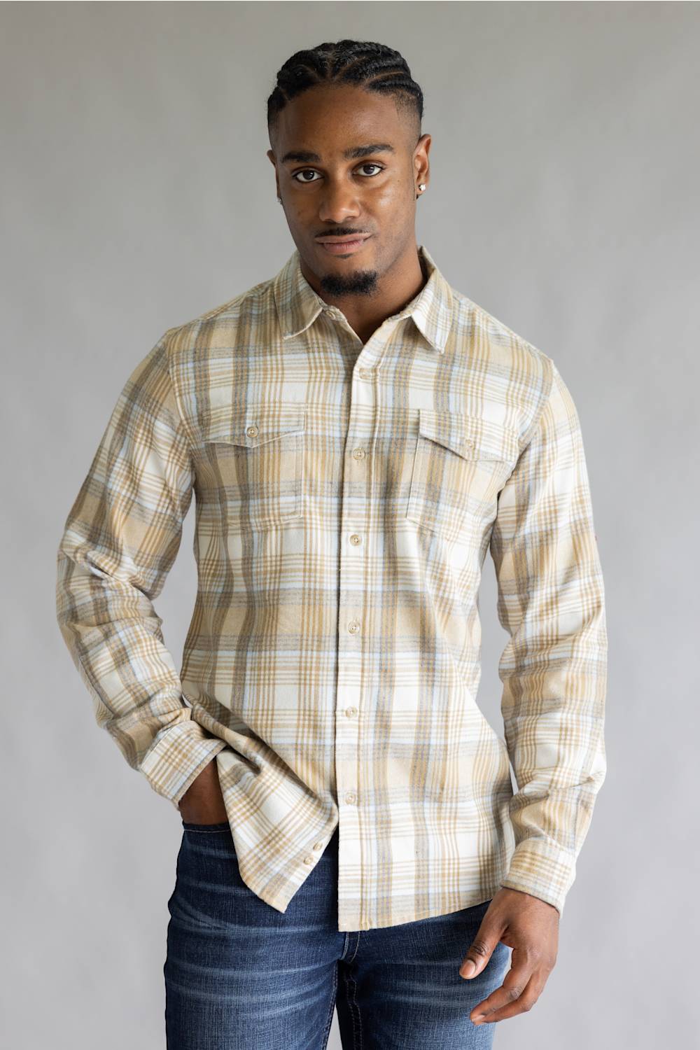 Model wearing the Split Men's long-sleeve flannel shirt in a beige, white, and light blue plaid pattern, featuring two chest flap pockets with button closures against a grey studio background.