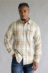 Model wearing the Split Men's long-sleeve flannel shirt in a beige, white, and light blue plaid pattern, featuring two chest flap pockets with button closures against a grey studio background.