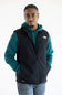 A person wearing a black vest over a teal hoodie, with The North Face logo printed in white on the upper right chest.