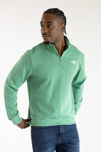 A man wearing the The North Face Evolution Simple Dome ¼ Zip Neck for Men in Dimmed Algae Green with a white The North Face Logo on the upper left chest.
