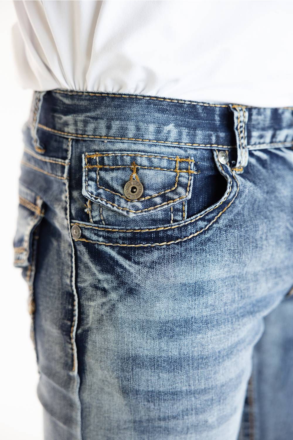 Close-up of a person wearing blue denim jeans with a white shirt tucked in, showing the back pocket and button detail.