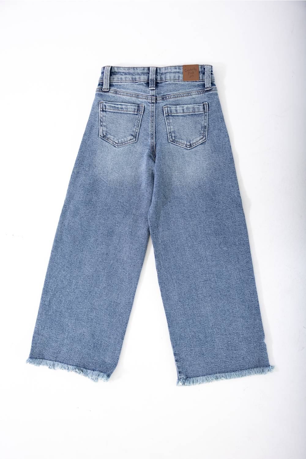 girls jeans laid on a plain white background