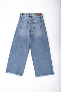 girls jeans laid on a plain white background