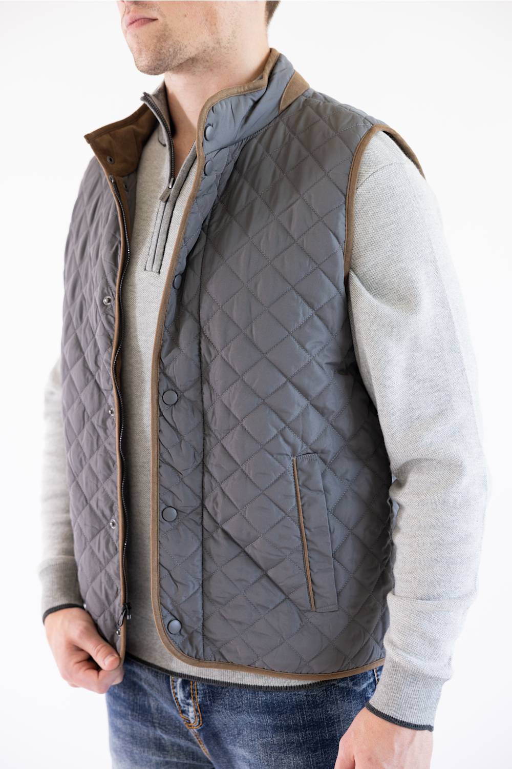 A close-up view showing the charcoal-colored diamond quilting, brown faux-suede trim, and snap-front closure of the FX Fusion Upland Quilted Field Vest.